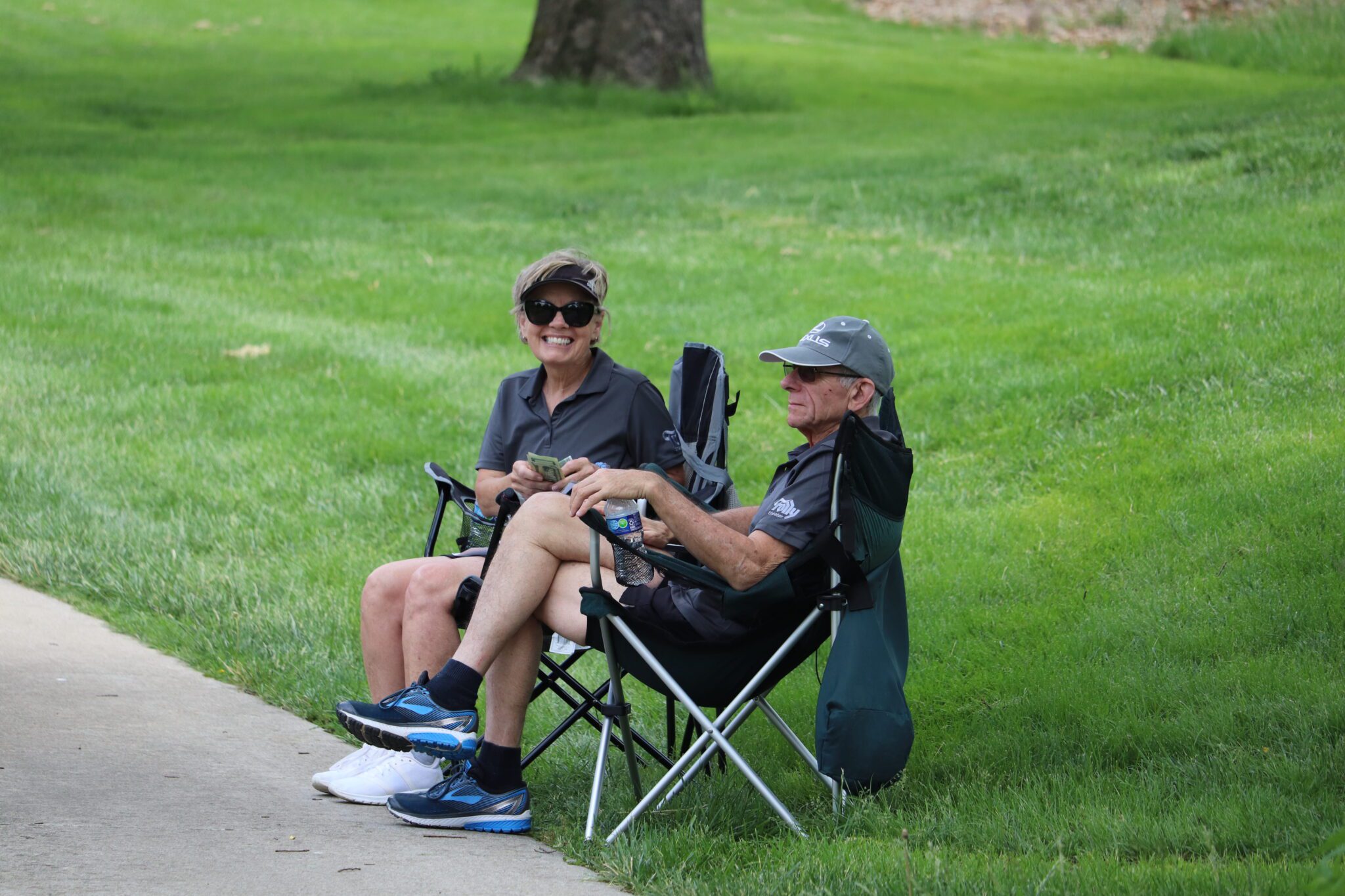 Volunteers sitting outside in lawn chairs on the grass